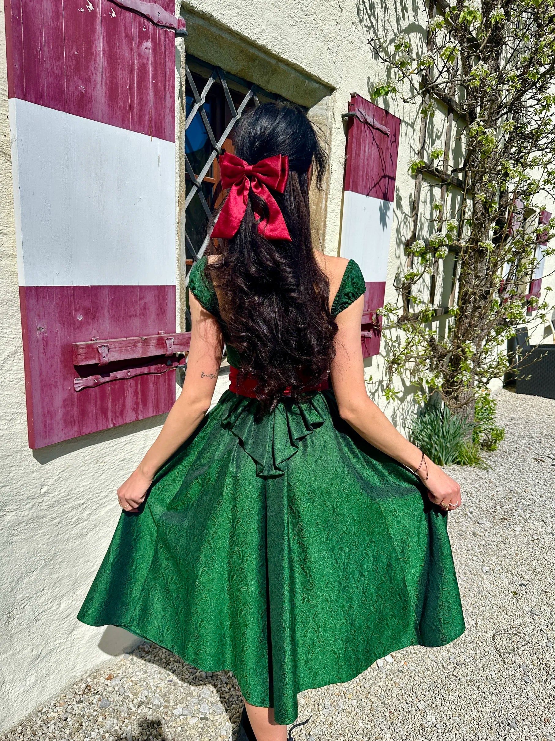 Smaragd grünes Dirndl Sissi Smaragd Edition an Frau getragen (Rückansicht) – elegante Trachtenmode in stilvoller Präsentation.