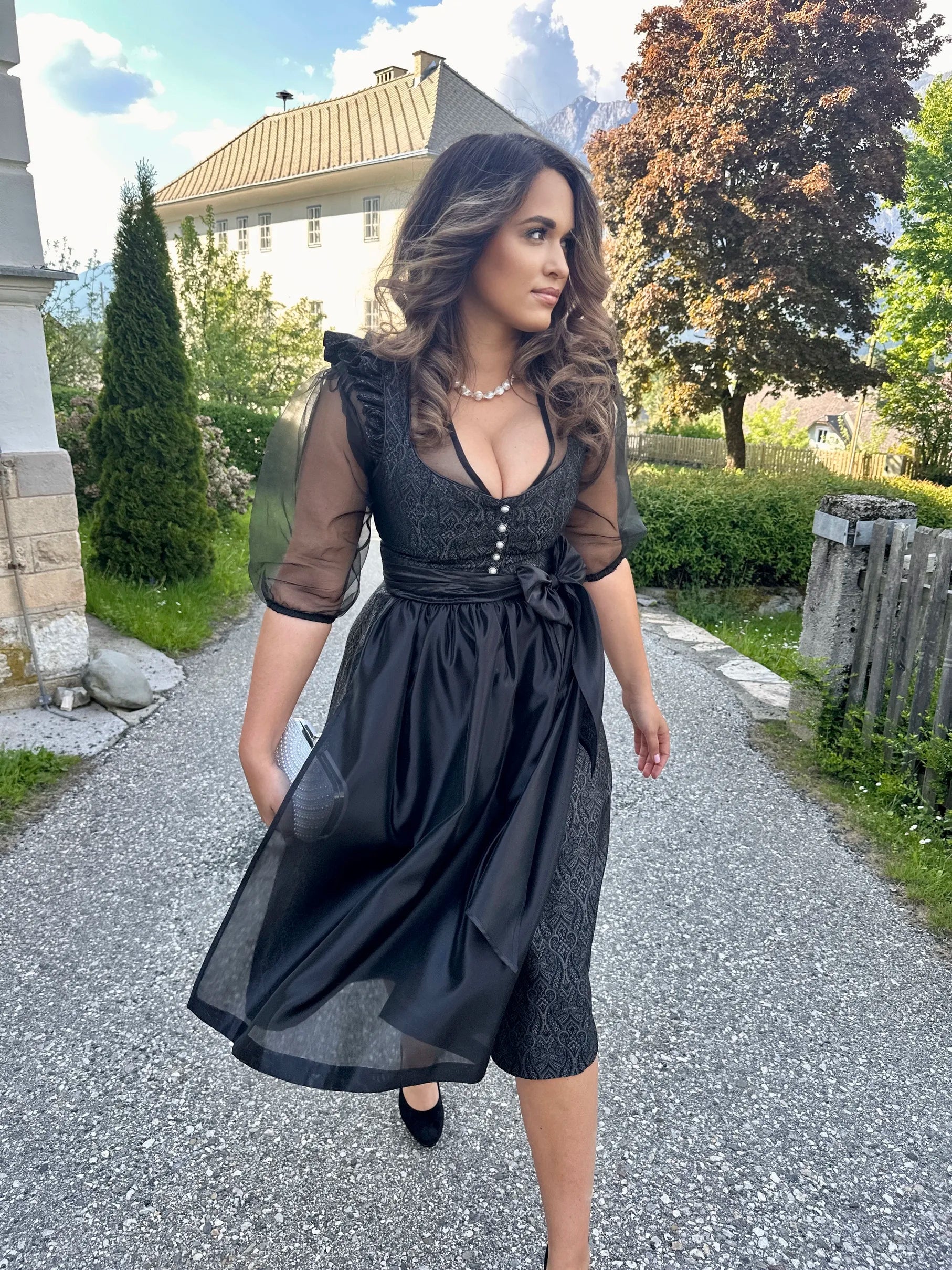Schwarzes Dirndl Imperial Noir und der schwarzen Bluse Helene Noire an Frau getragen – elegante Trachtenmode in stilvoller Präsentation.