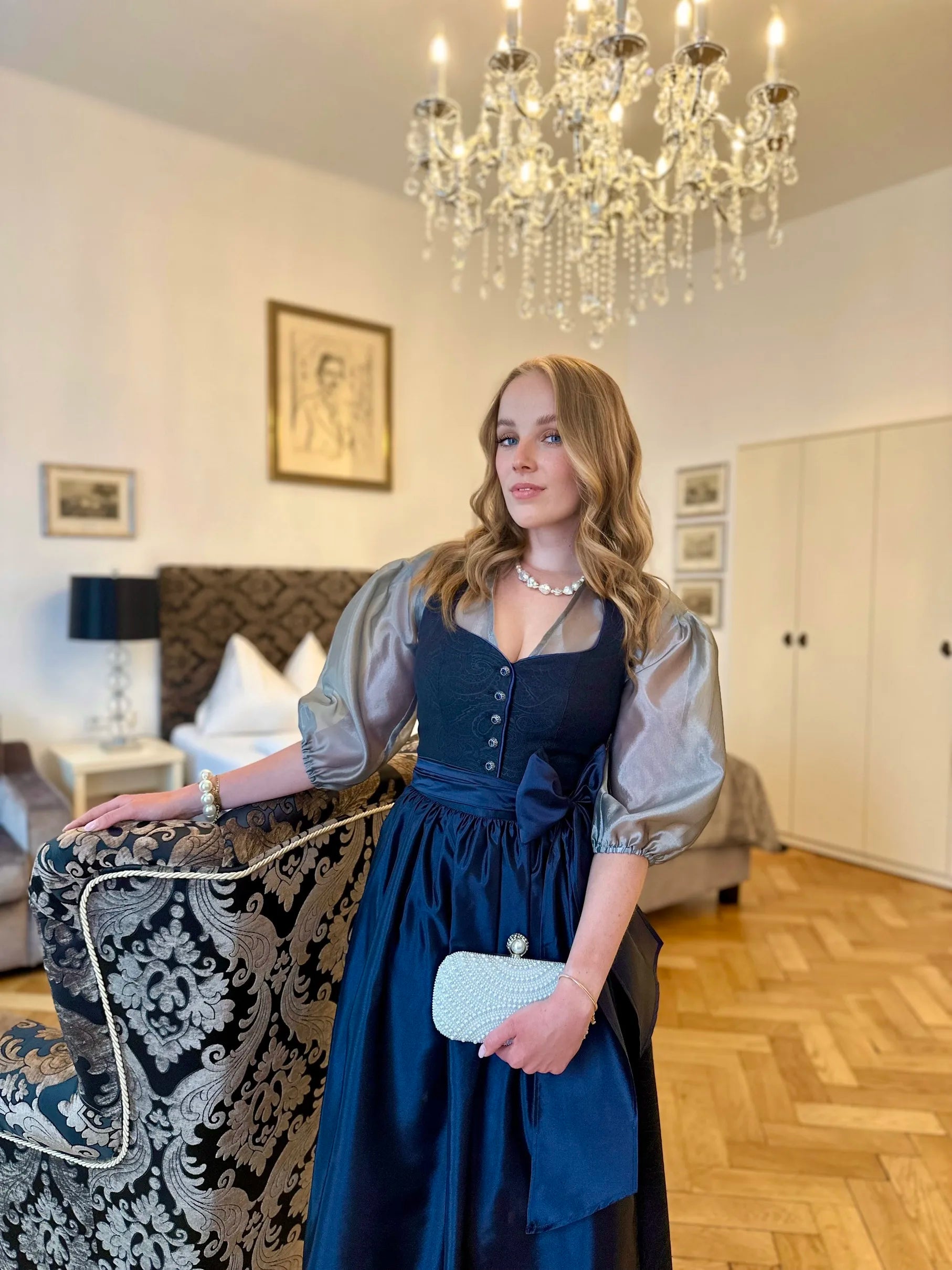 Zeigt das getragene mitternachtsblaue Dirndl Sophie Minuit und der silbergrauen Bluse Helene Argentee.