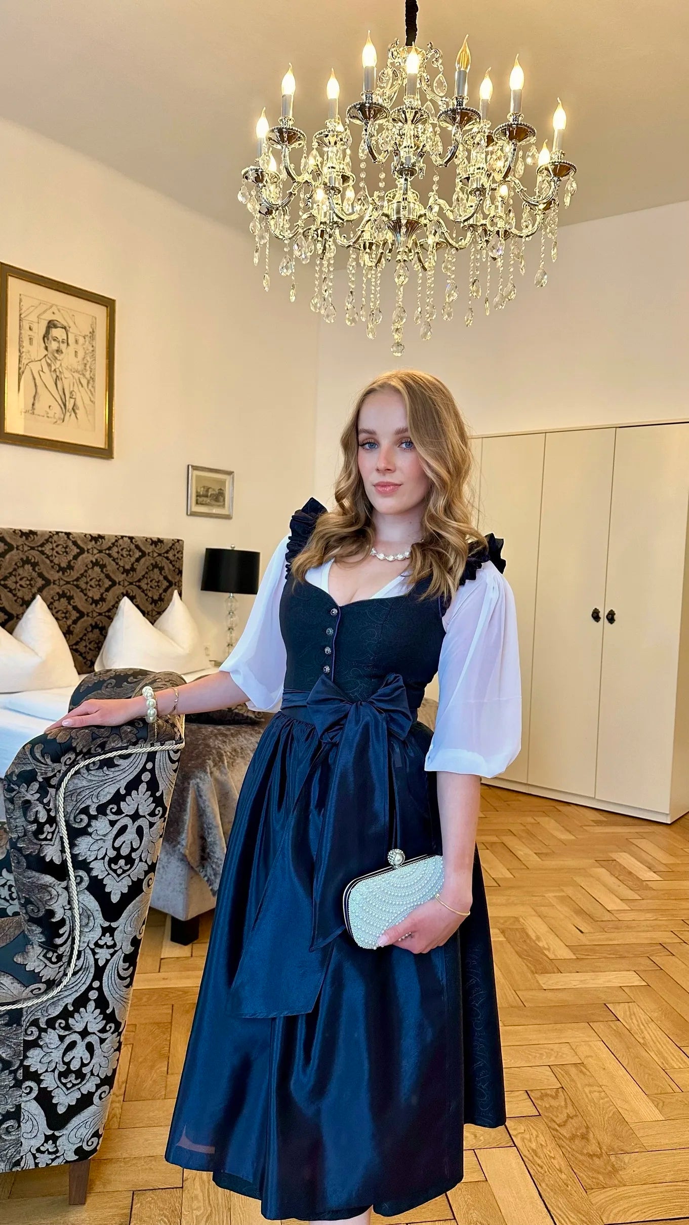 Zeigt das getragene mitternachtsblaue Dirndl Sophie Minuit und der weisen Bluse Helene Blanche.